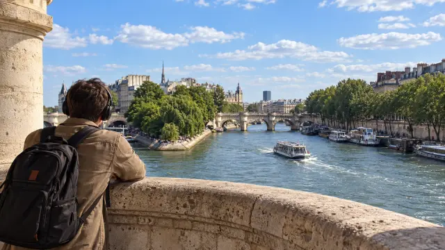 Una persona con auriculares en el Pont Neuf, junto a la isla de la Cité.