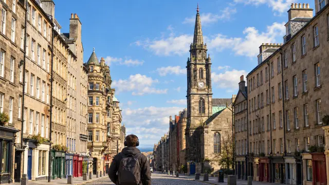 Una persona con auriculares pasea por la Royal Mile de Edimburgo.