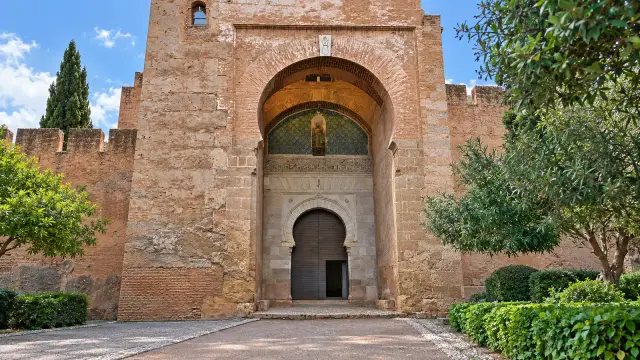 The Alhambra's Gate of Justice in Granada: a great horseshoe arch set in a tower of reddish walls