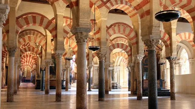 Rows of red-and-white striped arches stretching into the distance in the prayer hall of Córdoba's Mosque-Cathedral