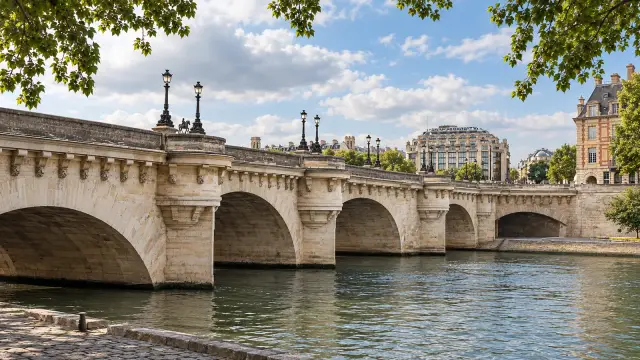 The Pont Neuf in Paris seen from the banks of the Seine, with its stone arches and half-moon bays
