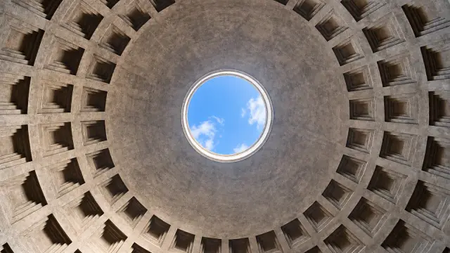 The oculus of the Pantheon in Rome seen from inside, with the coffered dome all around and the sky in the centre