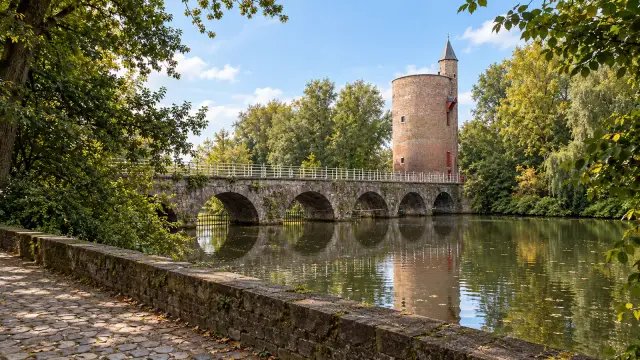 Bruges' Minnewater, the Lake of Love, with the round brick Poertoren tower by the water