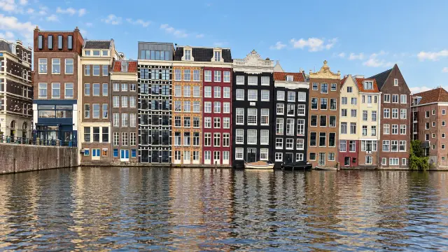 Narrow canal houses in Amsterdam with hoist beams and a façade leaning forward